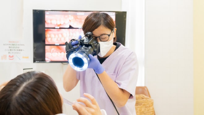 患者様の口腔内を撮影する歯科衛生士
